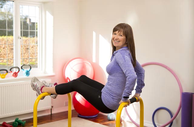A woman exercising with gym equipment in a fitness environment.