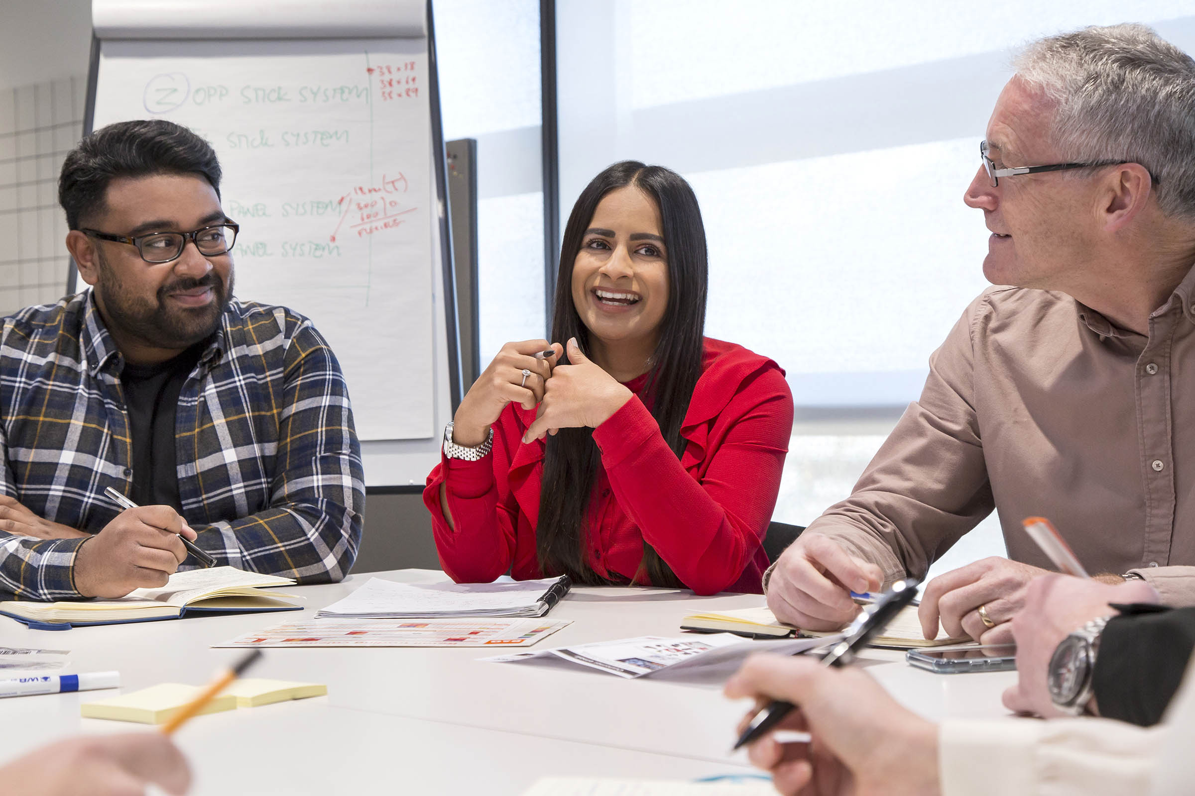 four people sat round a table in a business environment.